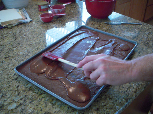 Smooth icing over warm brownies with spatula.