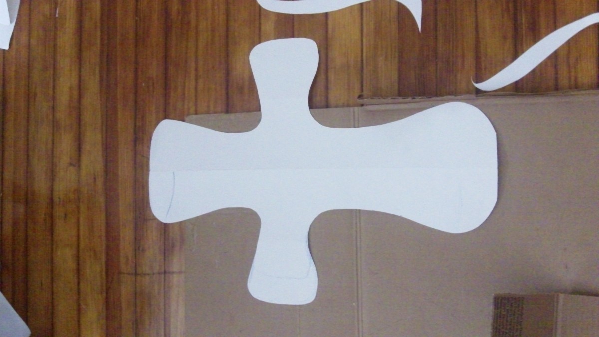 Fold paper in half and cut out a cross shape.
