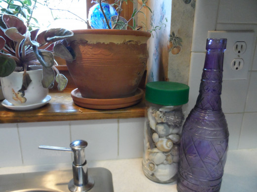 Beach, seashells and pretty glass bottles for a spring and summer theme for the kitchen window