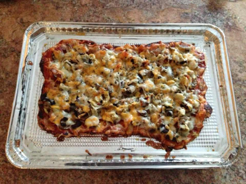 Finished product - pizza with tomato paste, olives, marinated artichokes, Crimini mushrooms, apple smoked bacon and four cheeses (Mozzarella, Monterey Jack, Cheddar, Parmesan)