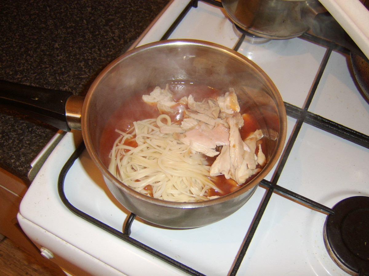 Chicken and noodles are added to sweet and sour sauce