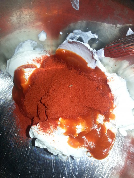 Add two spoons of chilli powder and three spoon of hot sauce to the Sour cream