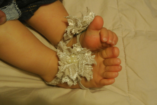 I reused an old shirt and some pearl beads to make this footless baby sandal for my baby.  