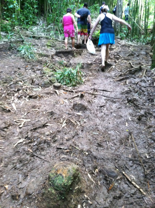 Some fellow hikers navigating the muddy trail.  Notice that they've taken off their sandals and are going at it with bare feet.