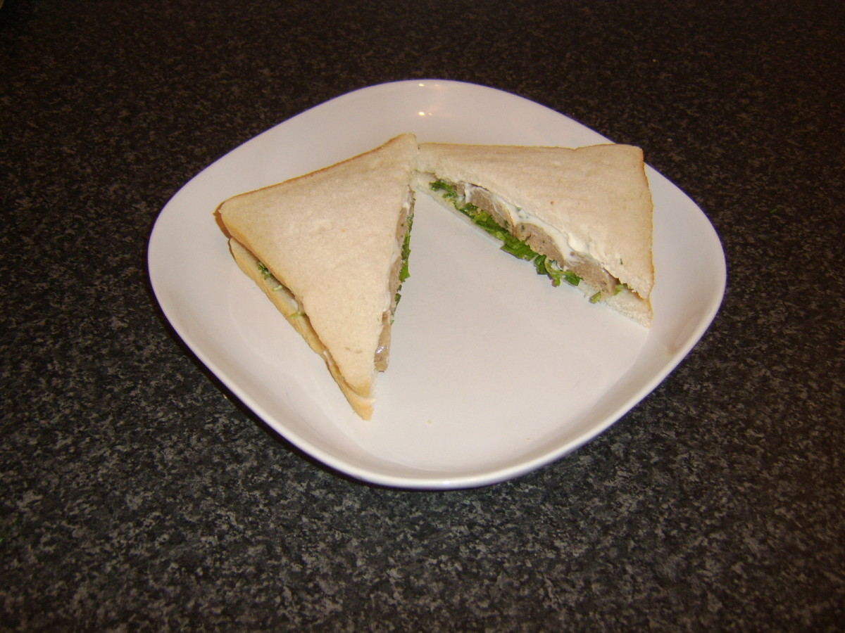 Sausage watercress and mayo sandwich is sliced to serve