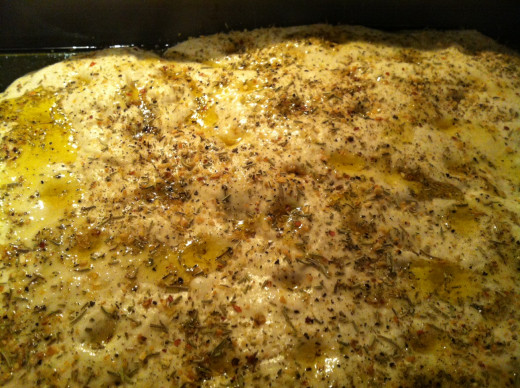 Gently poke indentations with your oil-dipped index finger and drizzle with olive oil, then top with herbs.