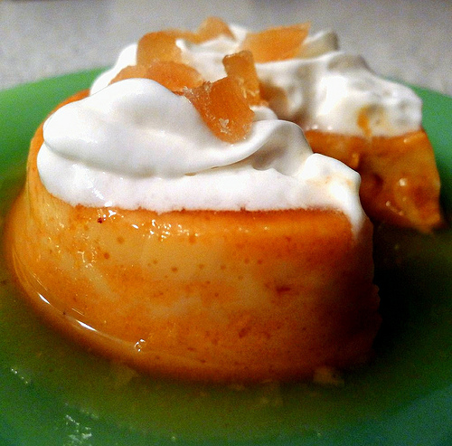 Pumpkin Flan served with whipped cream and candied ginger.