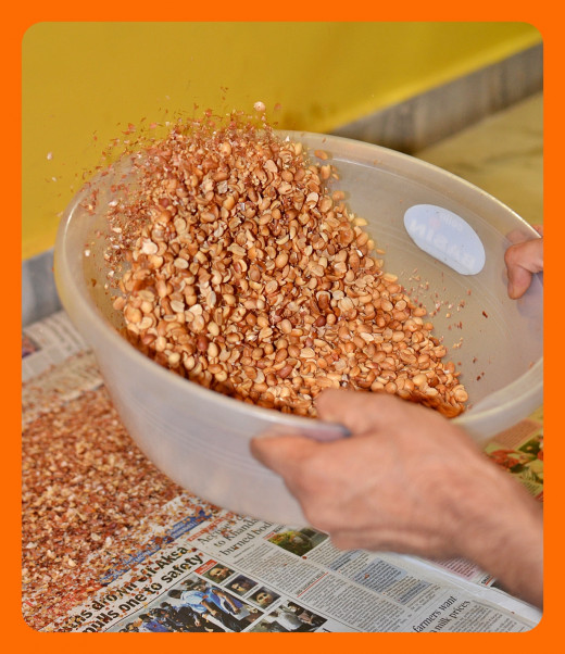 Tossing them carefully up will separate skin and nuts