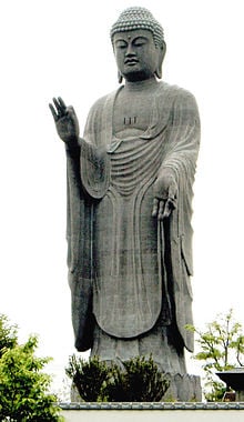 A huge statue of Amitabha, Ushiku Daibitsu, Japan. Amitabha is often depicted in the standing position with one hand lower down while the other in a hand sign. This is known as Mudra.