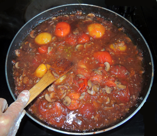 using a wooden spoon/spatula, break apart tomatoes and mix into sauce. Tomatoes should break easily at this juncture.