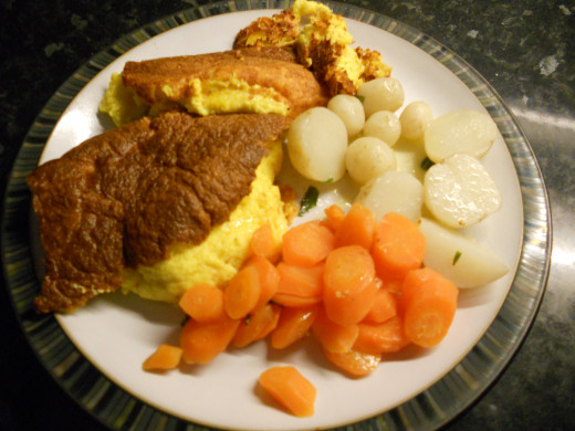 Cheese souffle served with minted baby new potatoes and buttered carrots