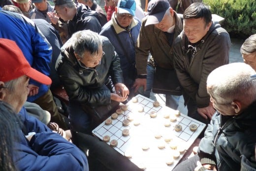 4 d) Senior Chinese men playing a board game at Temple of Heaven grounds
