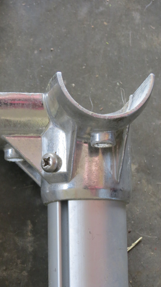 Bottom of corner assembly is attached to legs with one Phillips head screw.