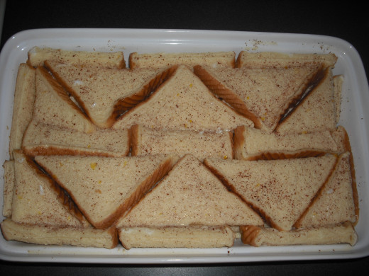 Pour the custard mixture evenly over the bread in the casserole dish.