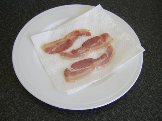 Bacon is drained on kitchen paper