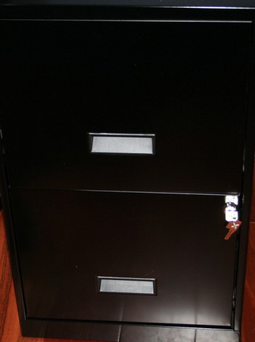 Inexpensive two-drawer file cabinet.  Top drawer contains files.  Bottom drawer contains envelopes and mailing supplies.  I keep my postage meter on top of the cabinet by my desk for quick access to weighing parcels.