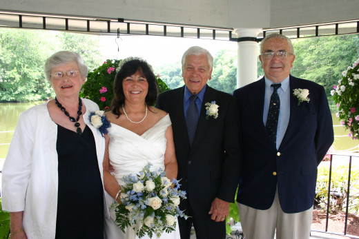 My husband and I flanked by my parents on our wedding day.