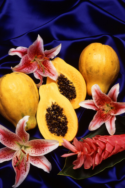 tropical papaya fruit displayed with tropical flowers.