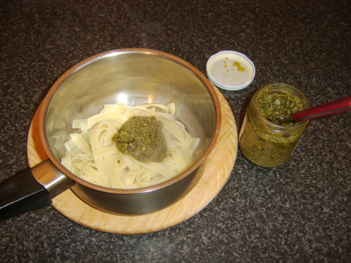 Green pesto sauce is added to drained linguine