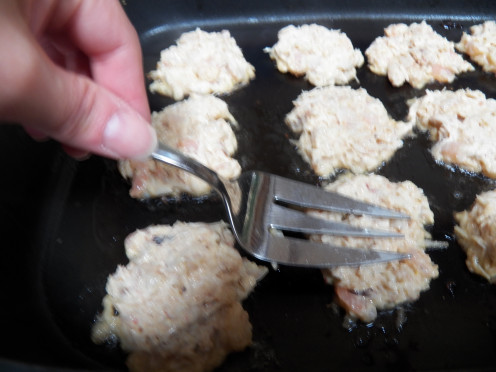 Flatten crab cakes with large fork.