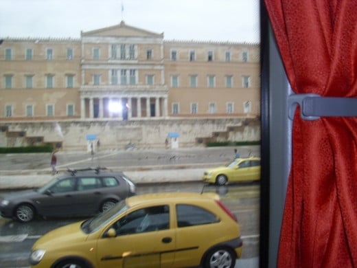 The Greek Parliament building taken from the bus. In the forefront are two yellow taxis.