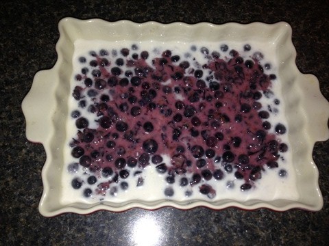 The final step before baking is to pour the blueberries on top of the dough.