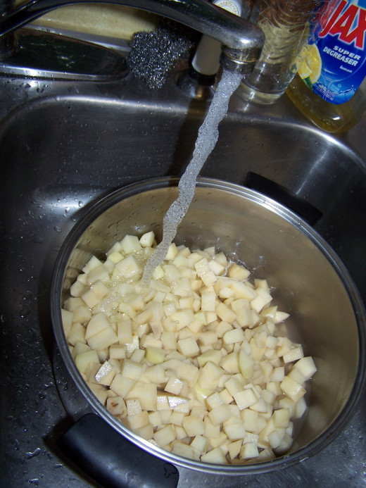 Here I am adding water to the stock pot of diced potatoes in preparation for boiling.