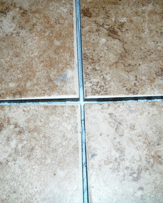 A tile spacer pushed down into the adhesive at a corner to keep the tiles square.