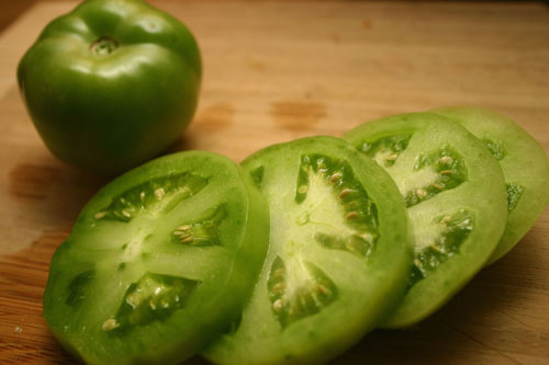 sliced green tomatoes, ready to be breaded and fried