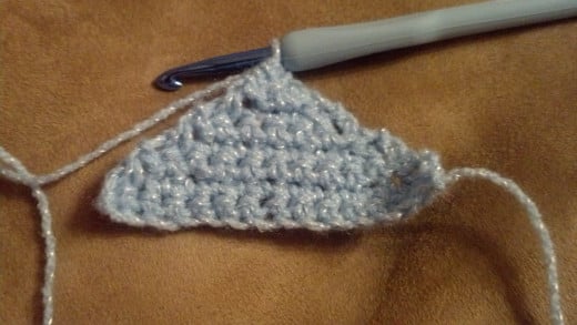 One cat ear hanging on the hook. This is a very small one. Make two and sew them together.