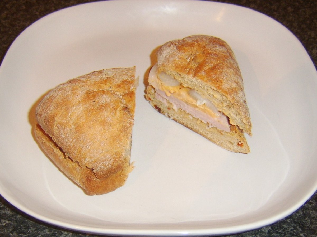 Ham, spicy cheese and pickled onion ciabatta is sliced and served