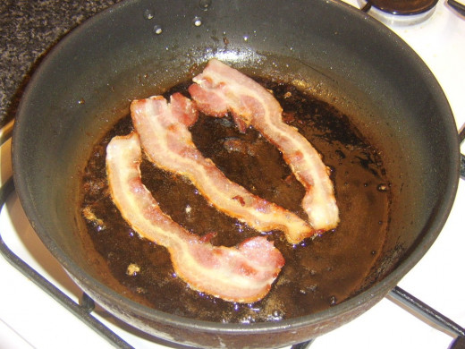 Bacon is fried in a little oil