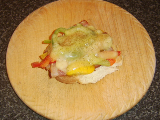 Cheese is melted over bell peppers and bacon