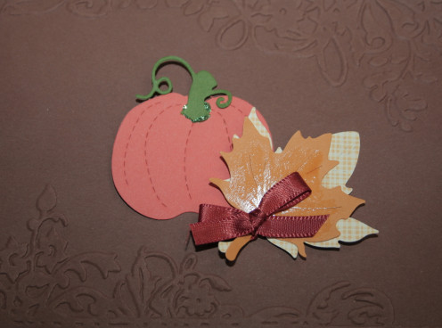 Pumpkin and leaf shapes adhered to embossed background.