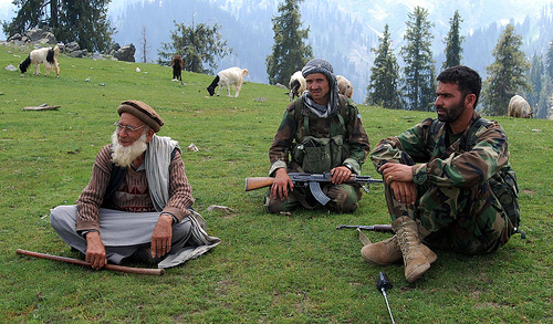 two Afghan soldiers chat to a local goat-herder. 