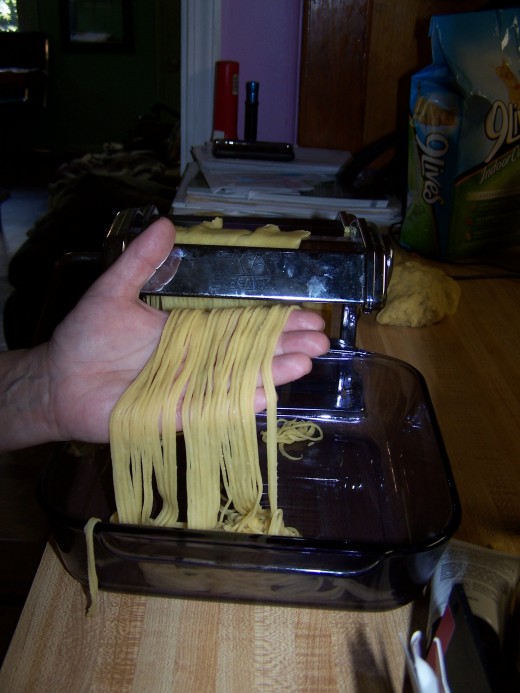 Here my assistant and I are forming the pasta through the pasta machine.