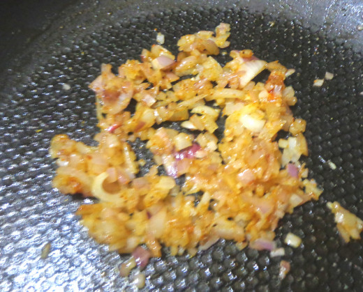 onions with sambar powder getting fried in the oil