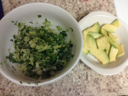 The lettuce mixture and sliced avocado.