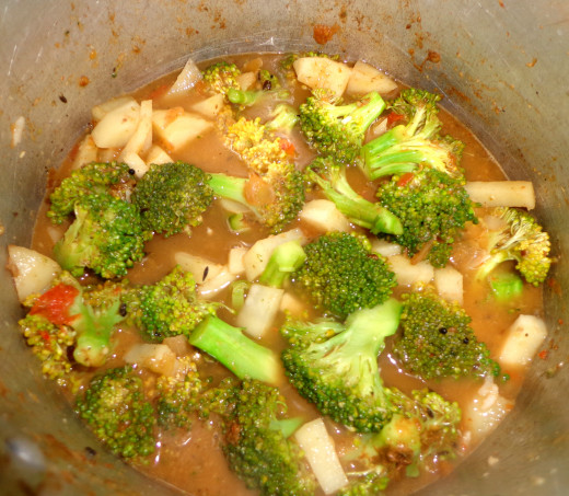 Broccoli and potatoes are added inside the same pan