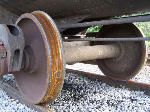Close-up view of a train axle; notice how the wheel and axle work together to let the train move easier.