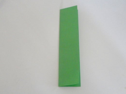 Fold the paper in half lengthwise to form the crease line.