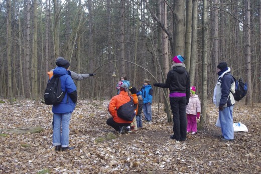 A family or two stocking up a bird feeder under the guidance of a guide at Hilton Falls Conservation Area. 
