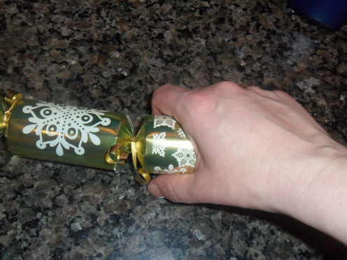Each person holds one end of the cracker and pulls.