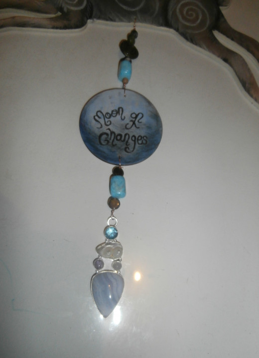 This sterling pendant was modified by me so that it could be hung on the bottom part. It features blister pearl, moonstone & blue lace agate.