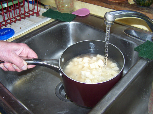 Here I'm adding water to the diced potatoes to boil them.