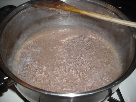 Begin by boiling 2 pounds of ground beef in 4 cups of water for about 30 minutes.