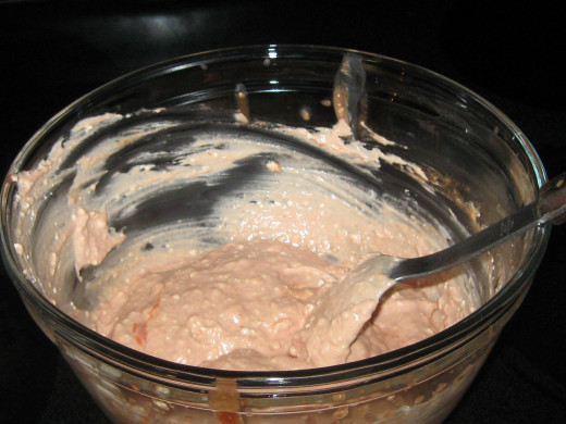Mixing tomato soup mixture over the cream cheese
