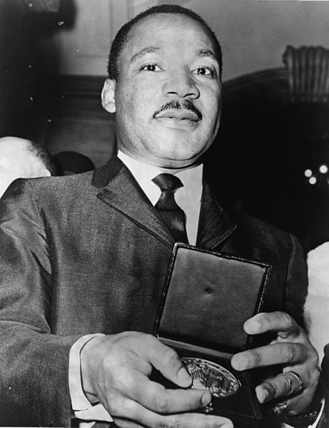 Martin Luther King Jr. is showing a medallion he received from Mayer Wagner in 1964