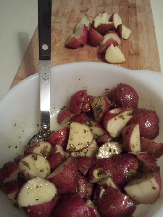 Add Potatoes a little at a time, mixing as you go to ensure they are all coated with olive oil mixture.