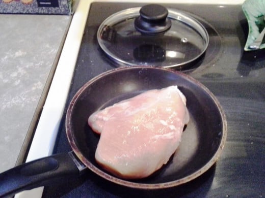 Step Two: Place your chicken in a skillet, cover, and cook over medium heat